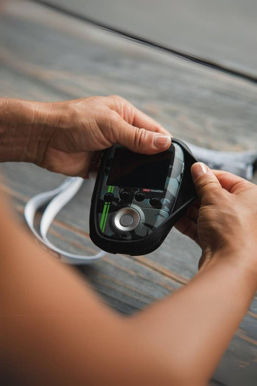 A person putting the Compex SP 8.0 WOD Edition into the Compex Protective Case for Wireless EMS Muscle Stimulators with lanyard (black)