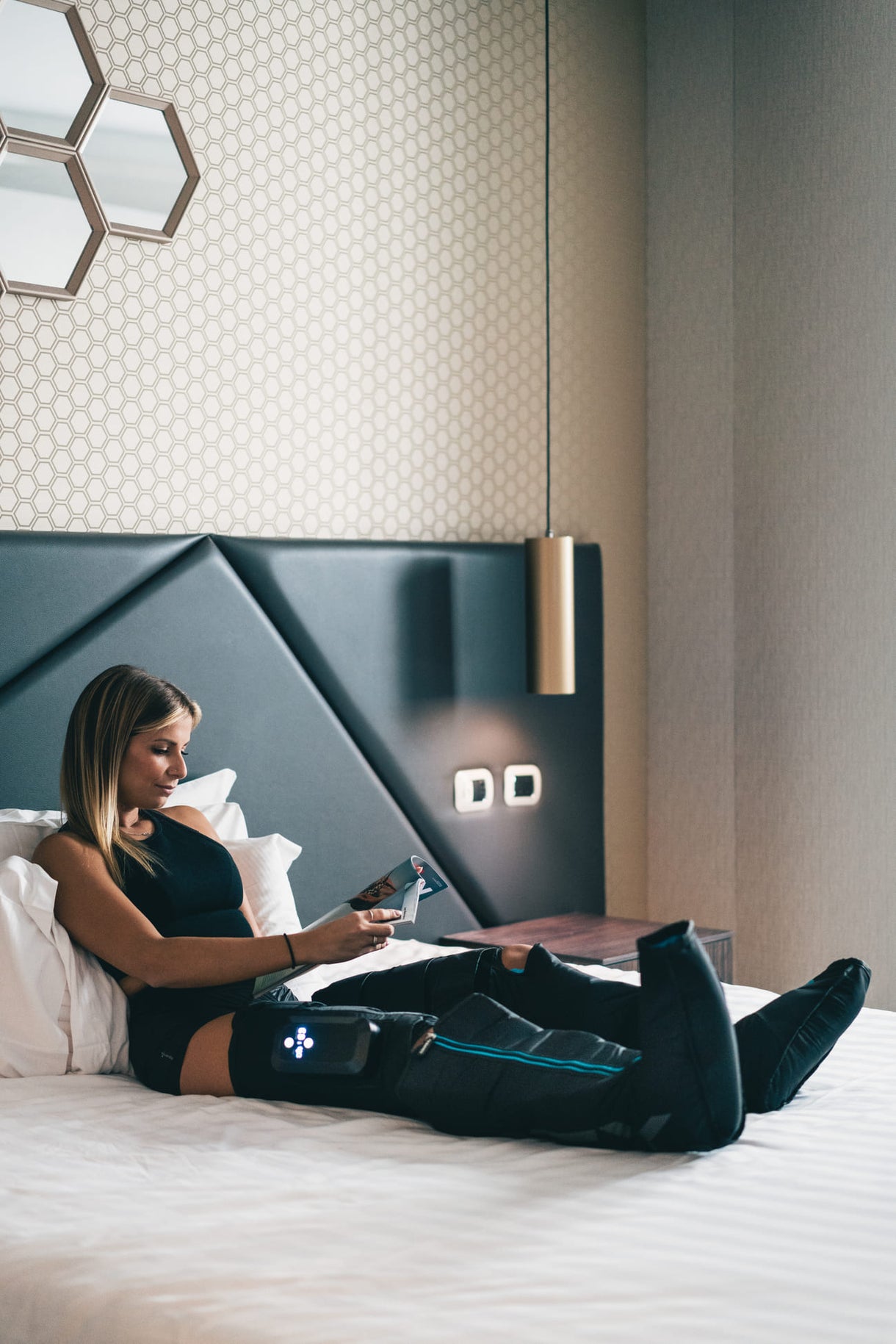 A woman using the Compex Ayre compression boots for muscle recovery