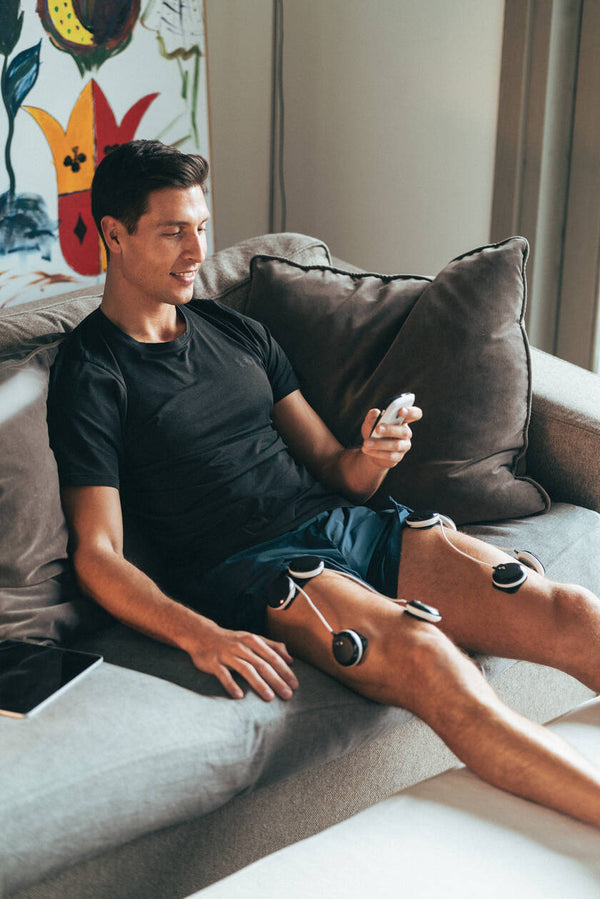 A man doing quad muscle recovery using the Compex SP 8.0 EMS muscle stimulator